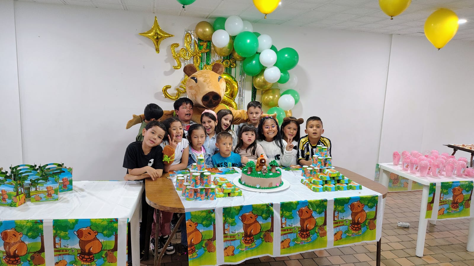 Niños felices celebrando cumpleaños con decoración colorida, globos y pastel en fiesta infantil casera